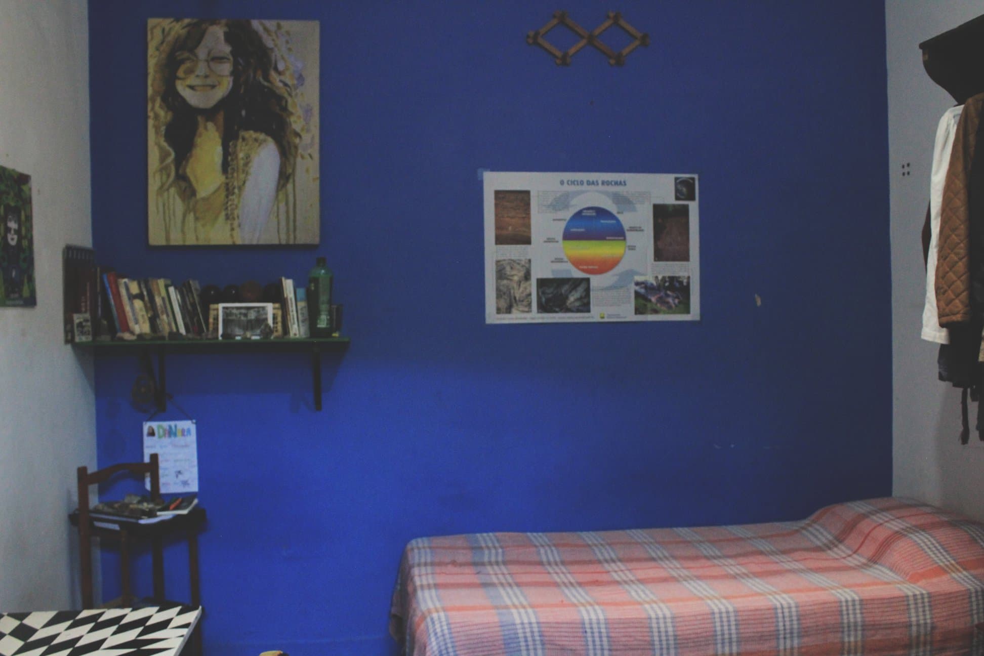 Quarto individual com mesa de estudo e armários.